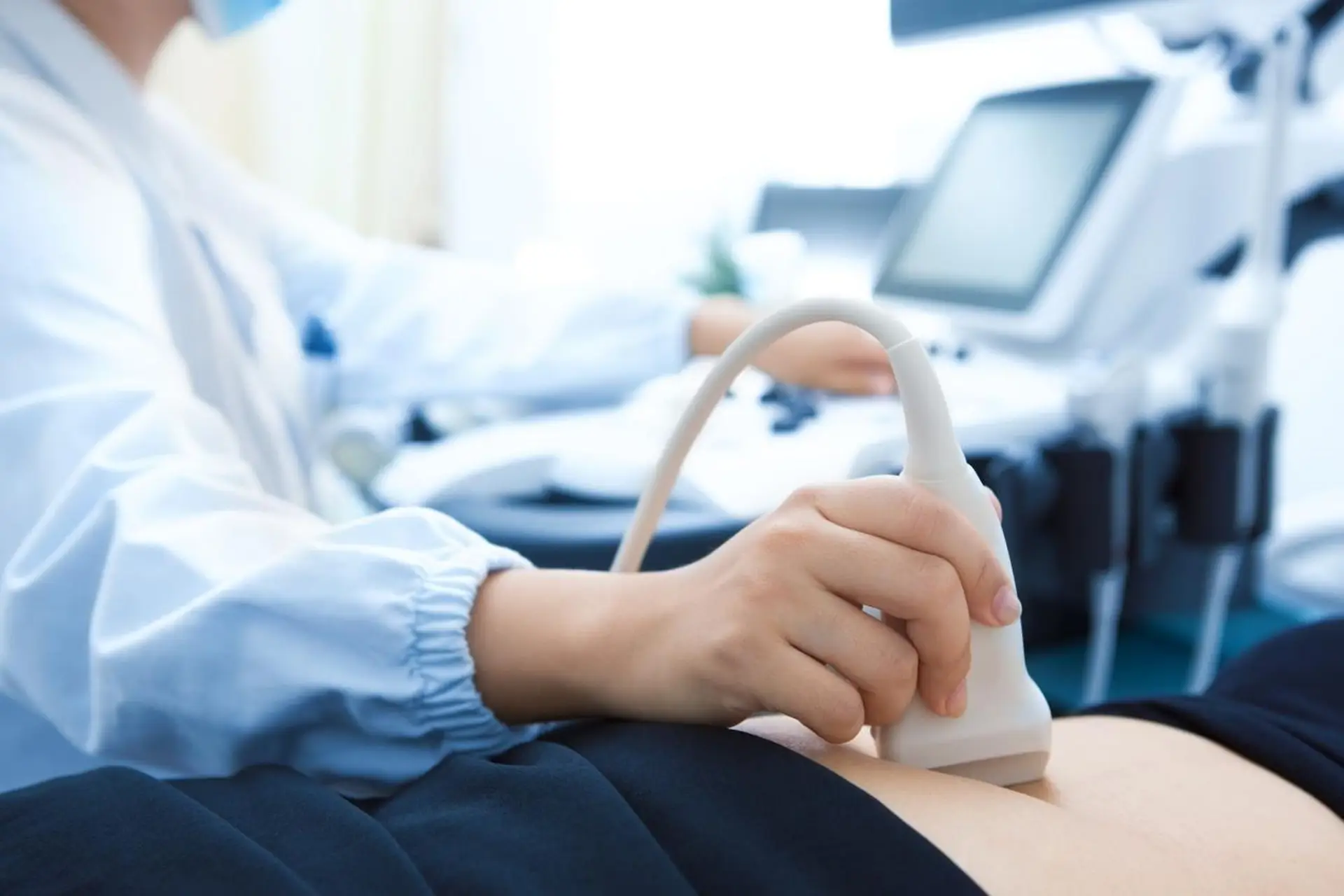 Illustrative ultrasound probe used on a patient’s abdomen
